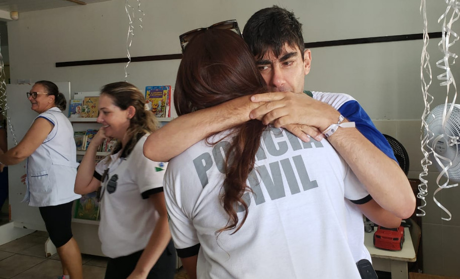 Policial civil recebendo abraço de aluno