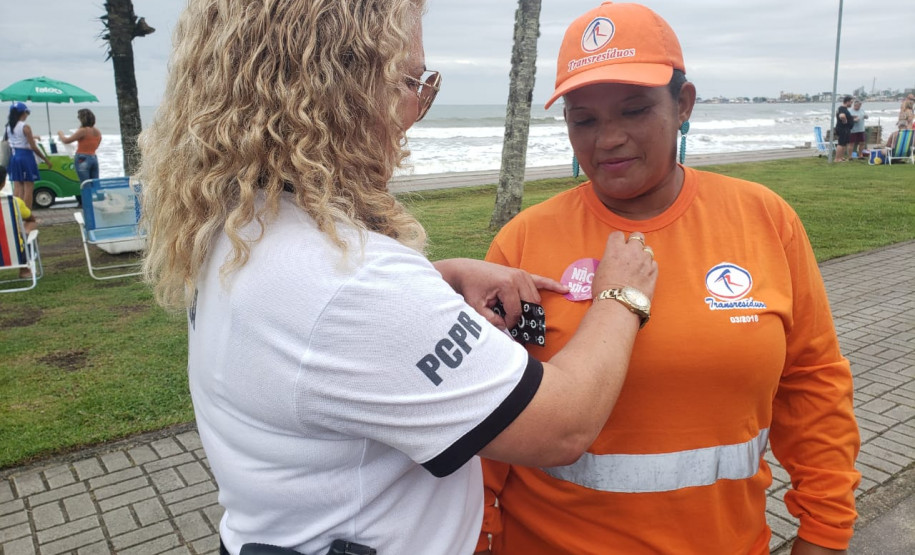 Policial civil colando o adesivo da campanha