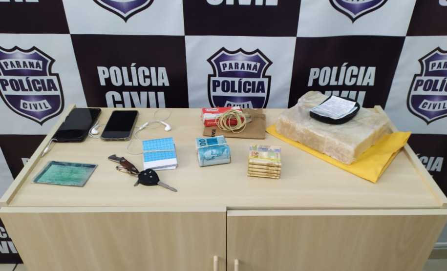 Produtos e dinheiro apreendidos, sobre um armário