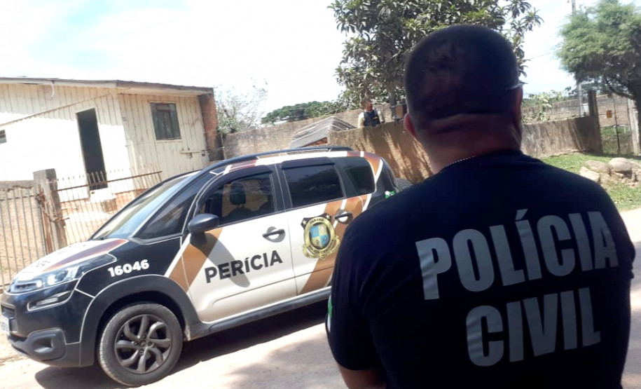 Policial civil ao lado de viatura