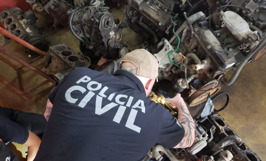 Policial civil observa motores de veículos desmontados