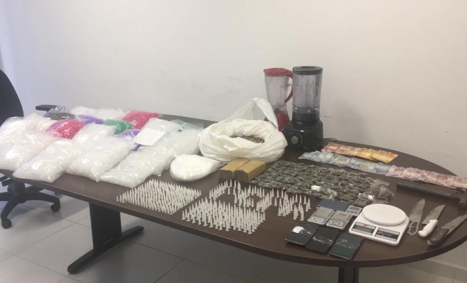 Drogas e demais produtos ilícitos apreendidos estão sobre mesa da delegacia