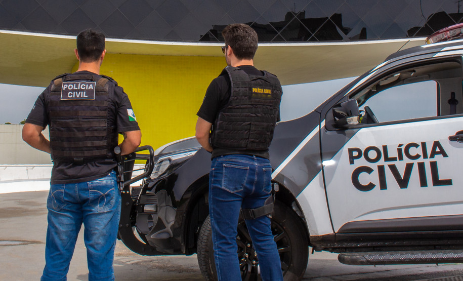 Policiais civis ao lado de viatura, em frente ao museu Oscar Niemeyer