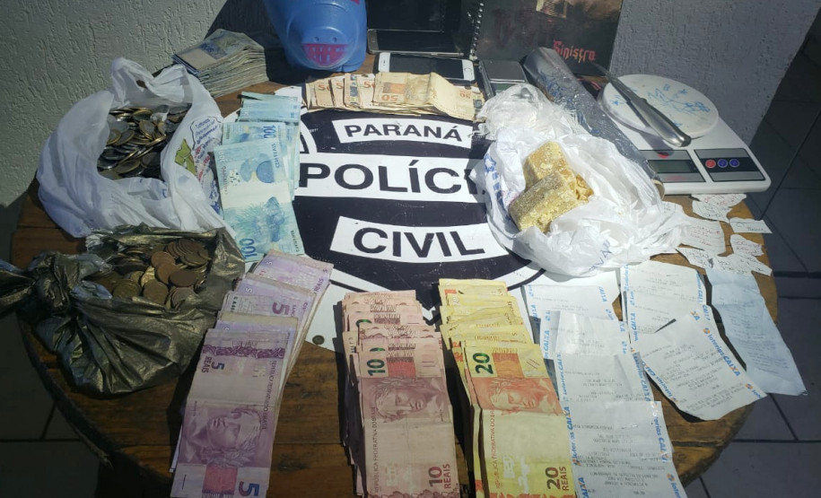 Entorpecentes, dinheiro e balança sobre uma mesa