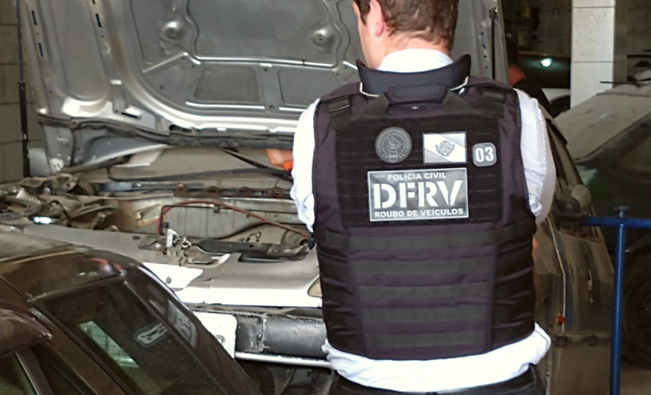 Policial civil de costas observando veículos