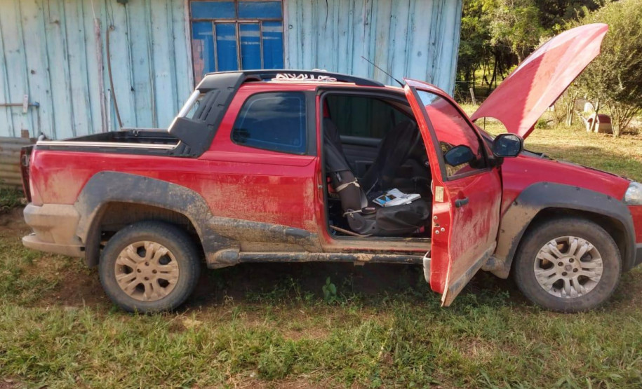 Ao lado da casa, veículo recuperado, com capô aberto