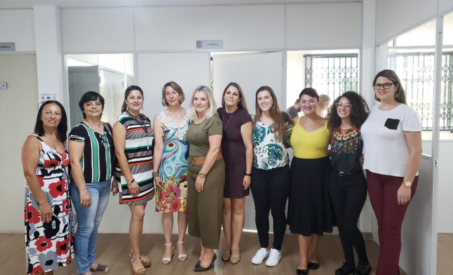 Participantes agrupados em pé, posando para foto