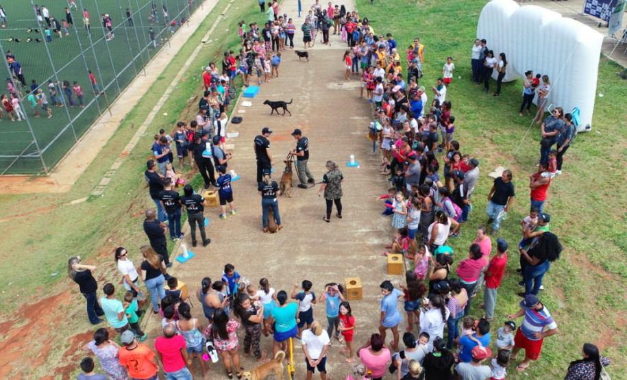 Imagem aérea mostrando apresentação com cães da polícia civil ao público