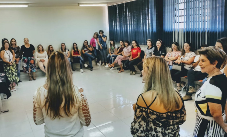 Participantes sentadas em círculo ouvindo a palestrante