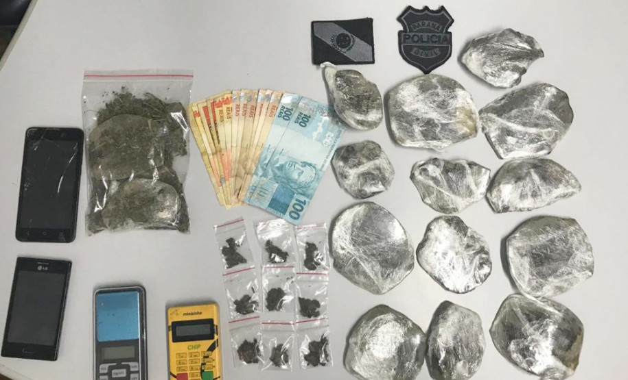 Drogas, máquina de cartão, celulares e dinheiro sobre uma mesa