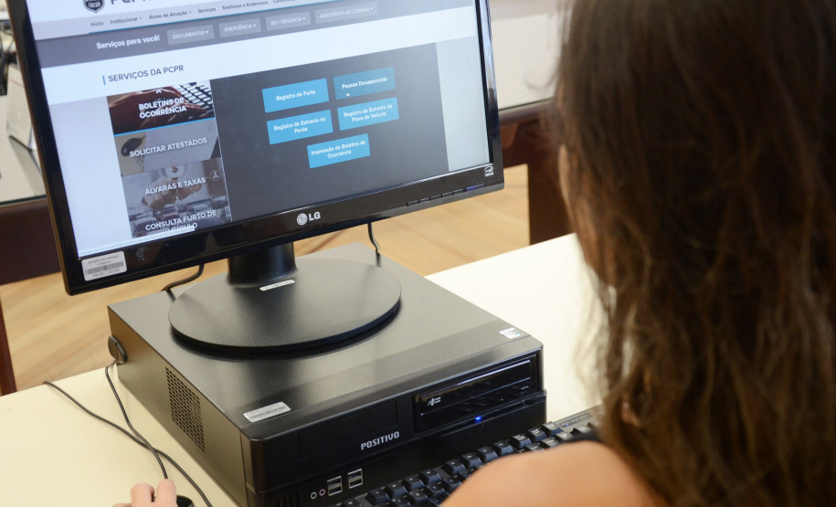 Pessoa ao computador, acessando página de serviços no site da Polícia Civil