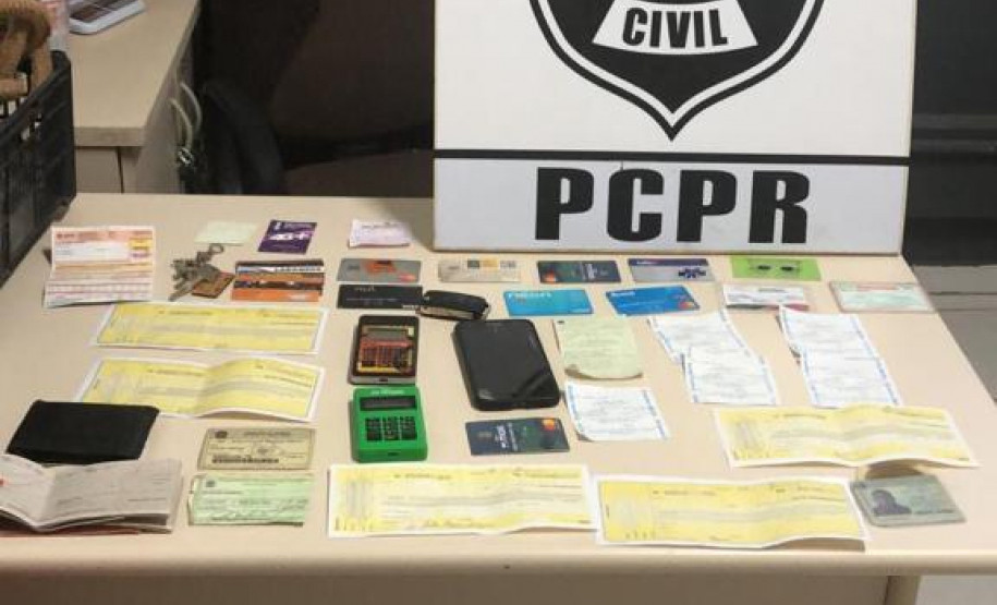 Mesa com diversos materiais encontrados na residência do suspeito de estelionato