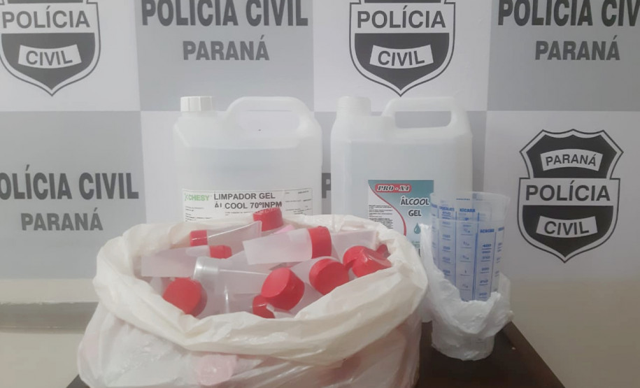 No interior de uma sacola plástica, diversos produtos apreendidos. Ao fundo, banner da polícia civil