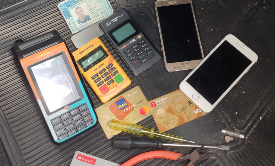 Ferramentas, celulares, cartões de crédito e máquinas de cartão, carteira de motorista no interior de veículo