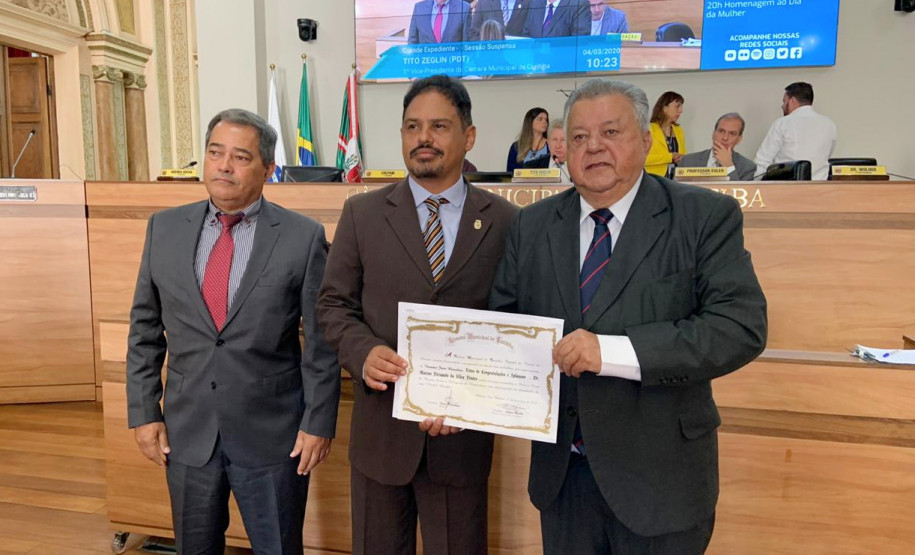 Homenageado recebendo diploma em foto posada
