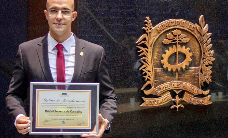 Delegado posando para foto, mostrando o diploma