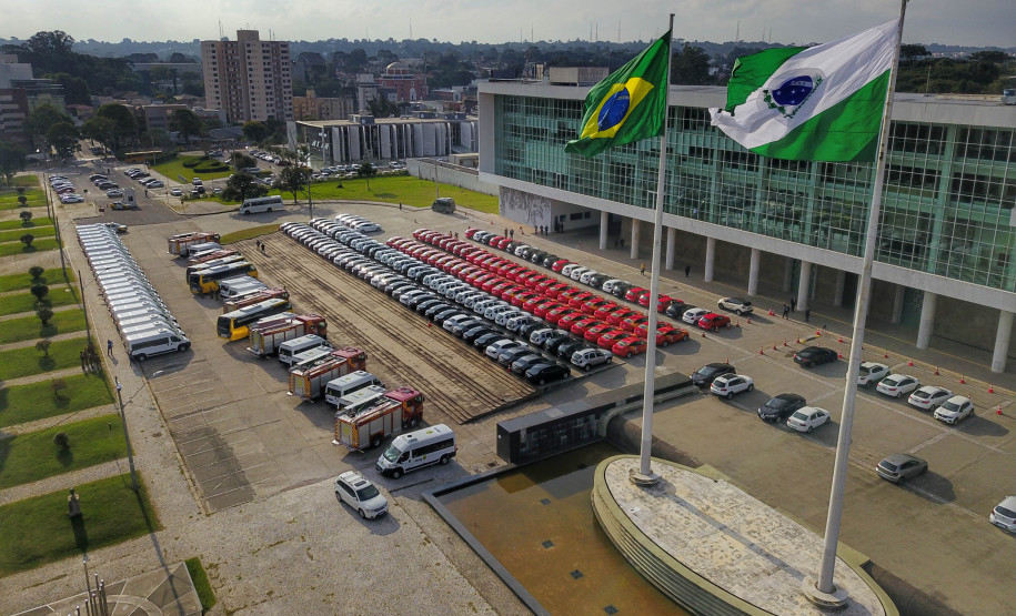 Fotografia aérea mostrando os veículos entregues, as bandeiras do Brasil e do Paraná e o Palácio Iguaçu.
