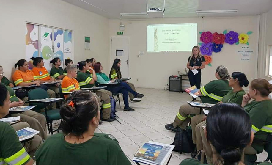Diversas mulheres sentadas assistindo a palestra