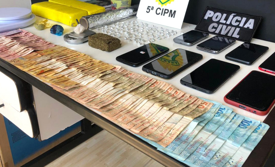 Objetos e dinheiro apreendidos, sobre a mesa