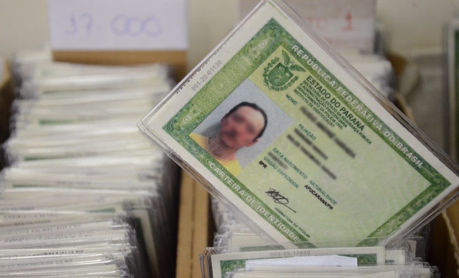 Centenas de documentos em caixas, com um RG em destaque