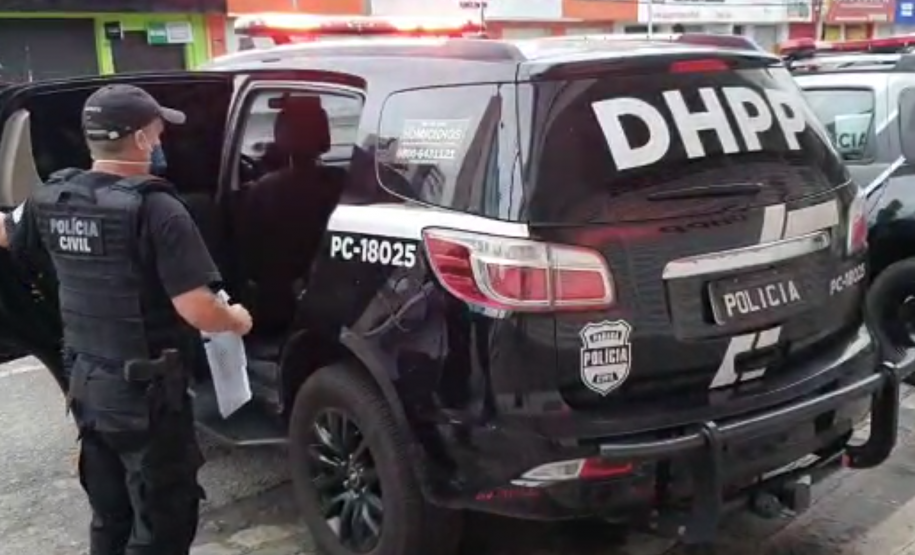 Policial civil próximo a viatura