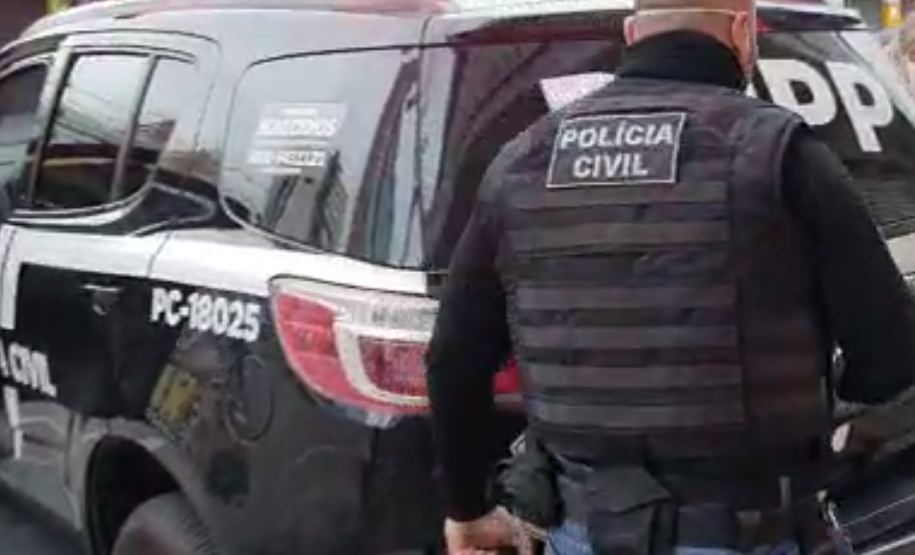 Policial civil próximo a viatura