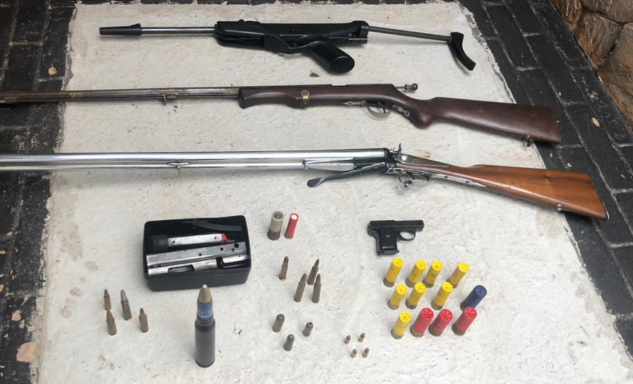 Diversas armas e munição sobre uma mesa