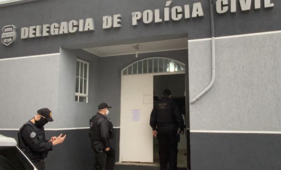 Três policiais civis entrando na delegacia