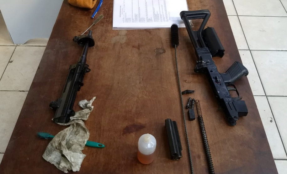 Armas desmontadas e material de limpeza sobre uma mesa