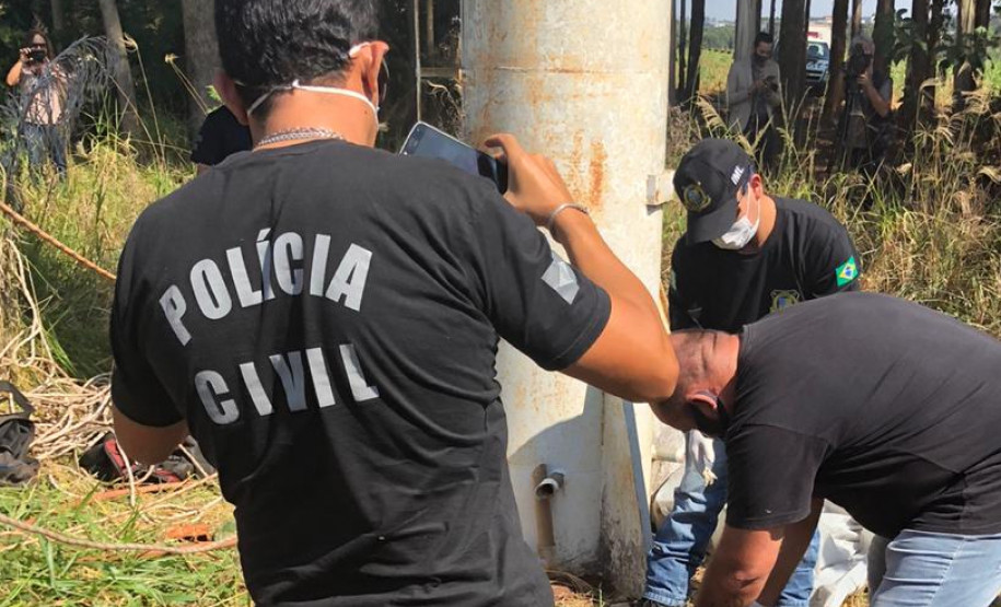 Policiais civis resgatando o corpo