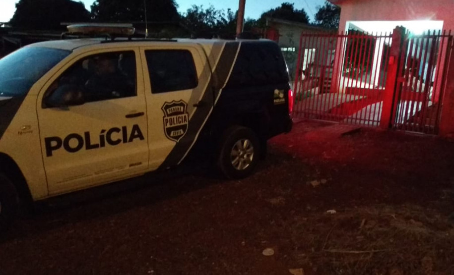 Viatura da polícia civil estacionada em frente a uma residência.