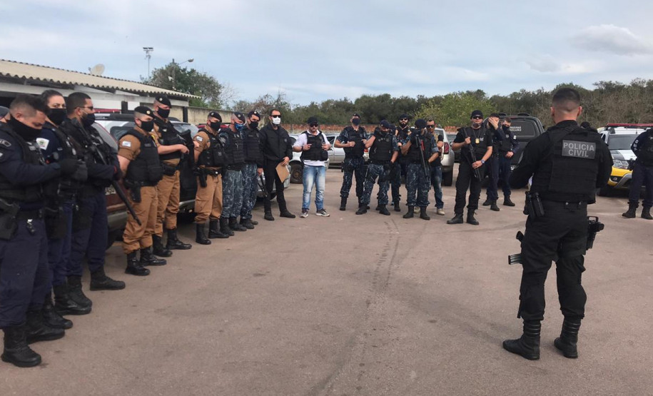 Vários policiais reunidos, recebendo instruções