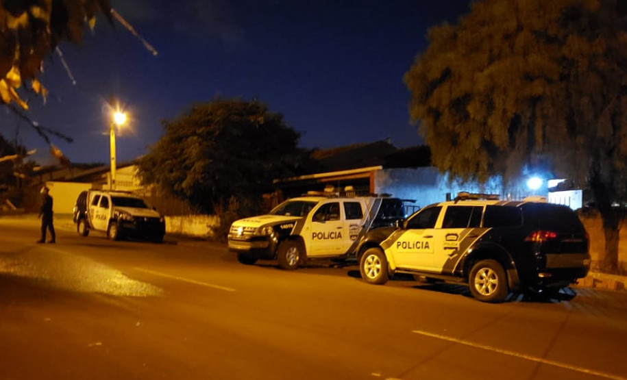 Três viaturas da polícia civil estacionadas e um policial andando