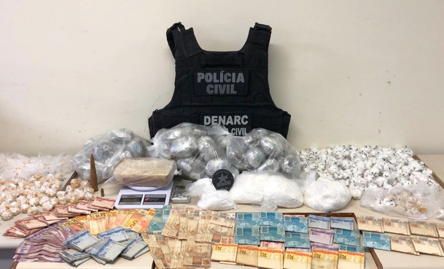 Dinheiro e droga apreendidos, sobre uma mesa