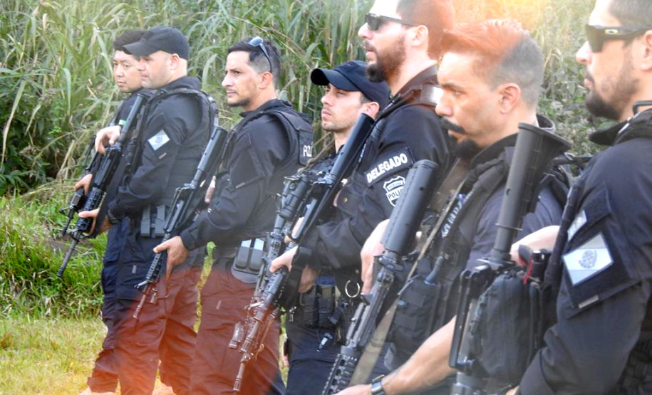 Policiais civis alinhados, empunhando fuzis