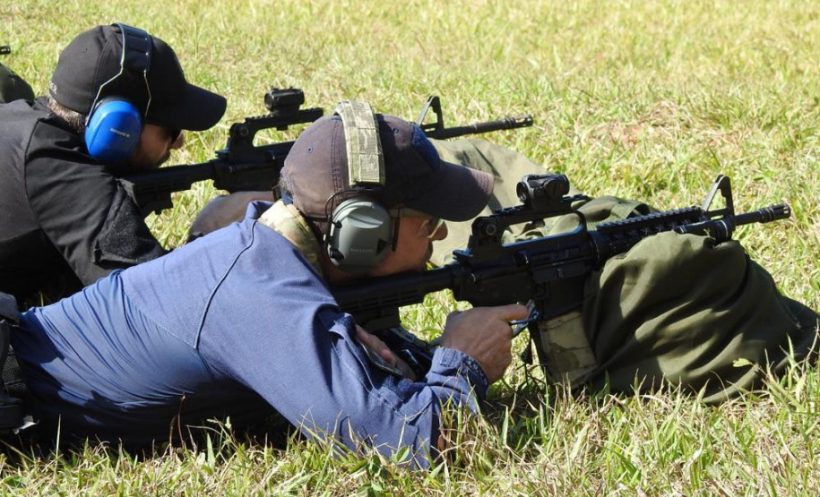 Dois policiais deitados no chão, apontando fuzis para alvos