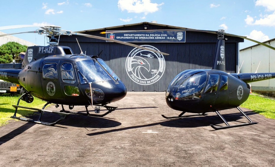 Dois helicópteros do GOA em frente a hangar