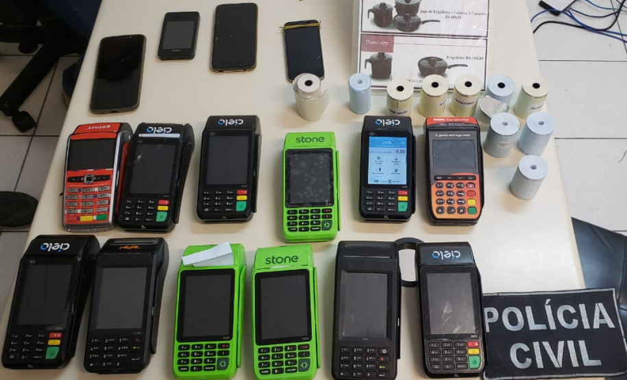 Diversas maquinas de cartão e celulares sobre uma mesa