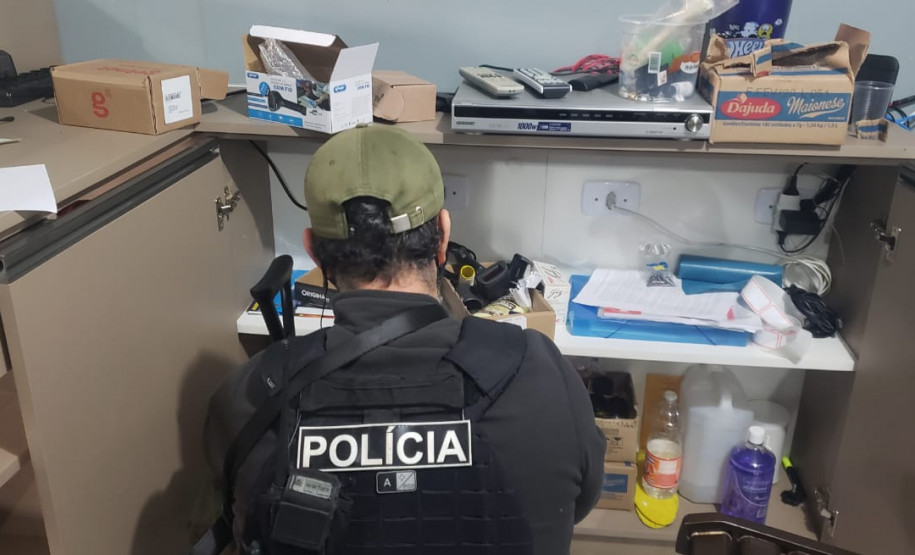 Policial civil investigando prateleiras com diversos objetos