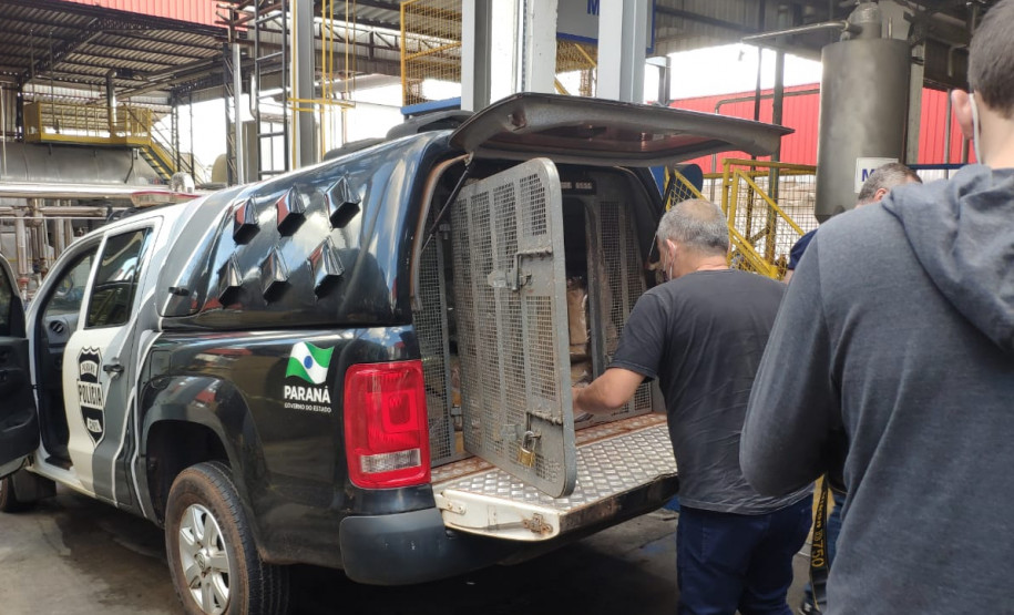 Policial civil retirando tabletes de droga da viatura