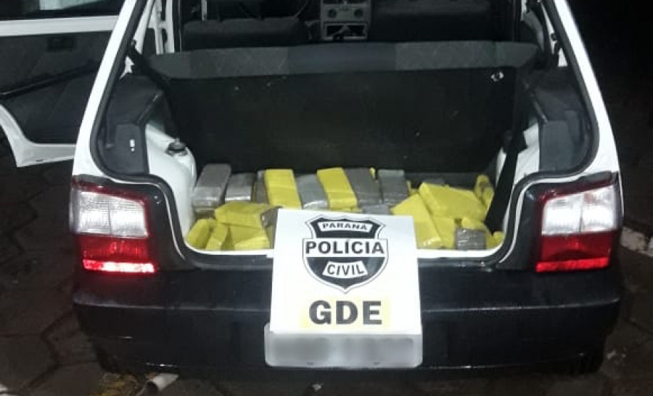 Veículo com porta-malas aberto. No interior, dezenas de tabletes de droga.