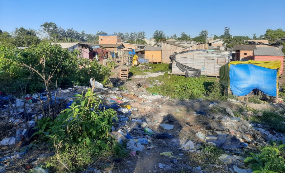 Várias casas em meio à área com muito lixo