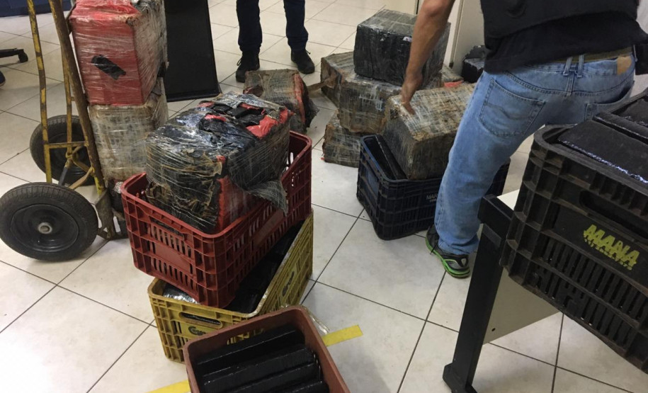 Policial organizando caixas com a droga