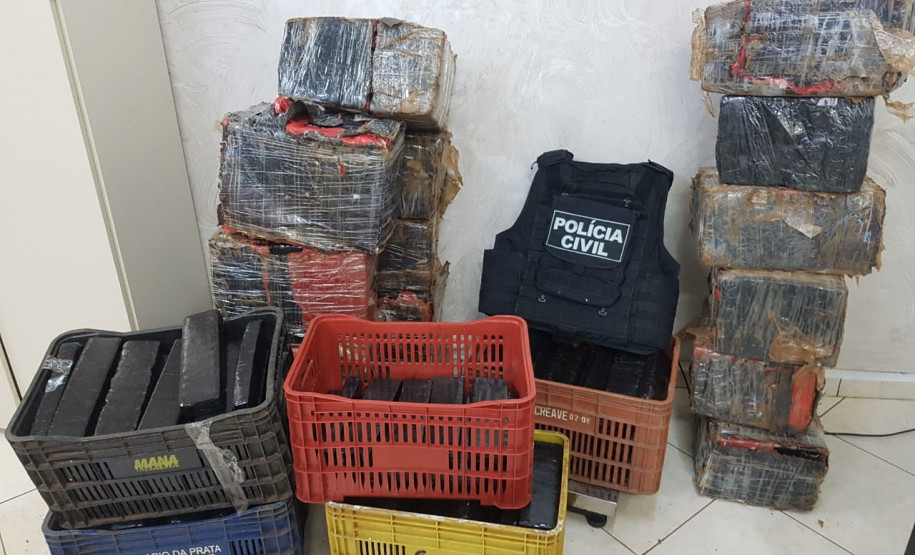 Diversas caixas com a droga e colete da polícia civil