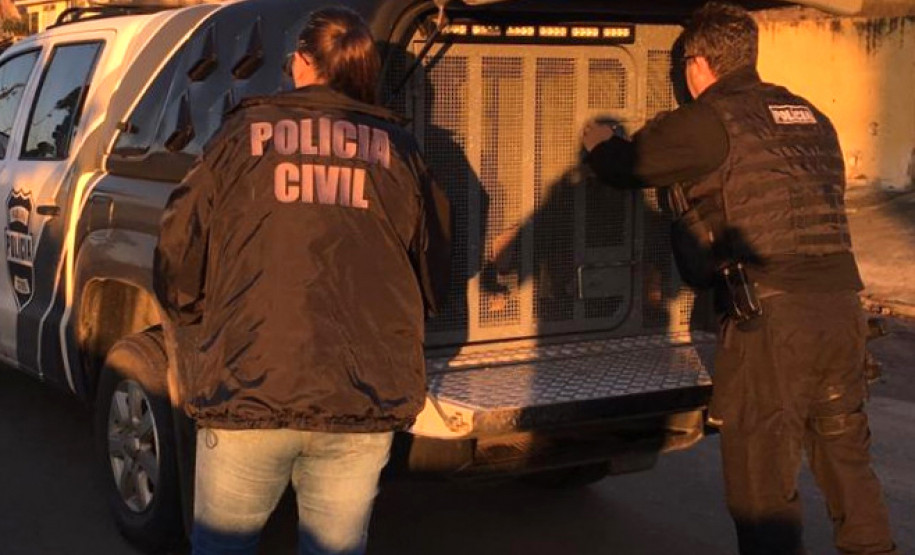 Policiais civis ao lado de viatura