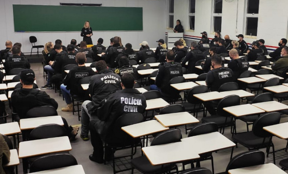 Policiais em sala, recebendo instruções antes da operação