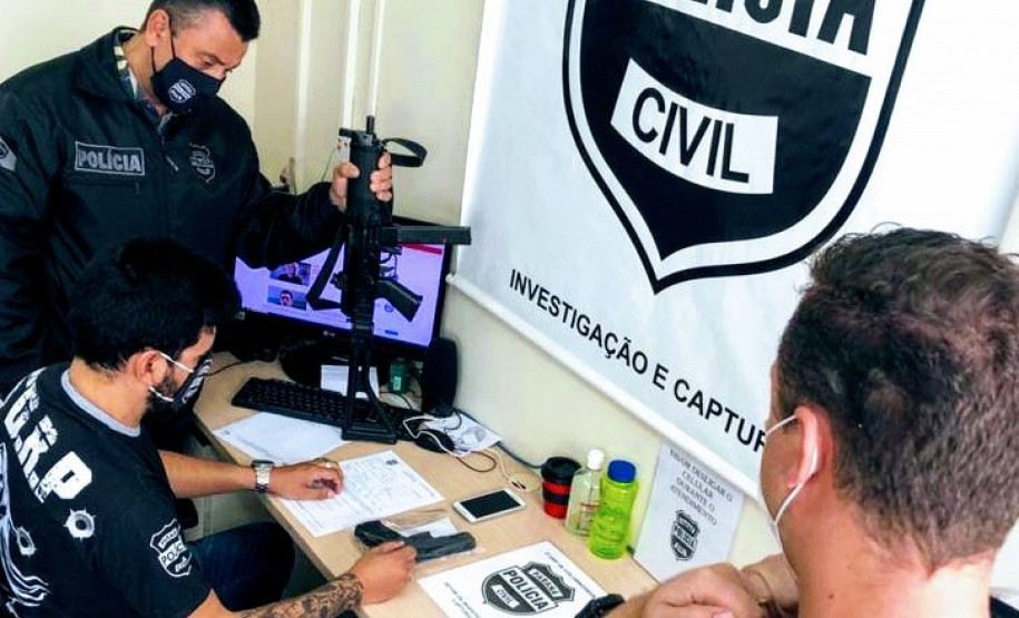 Policiais em uma mesa, averiguando material apreendido