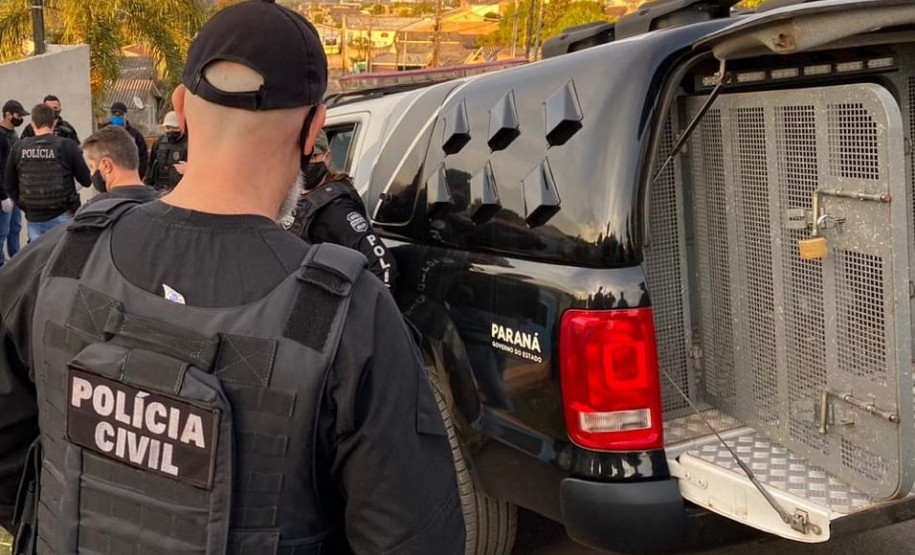 Diversos policiais civis ao lado de viatura