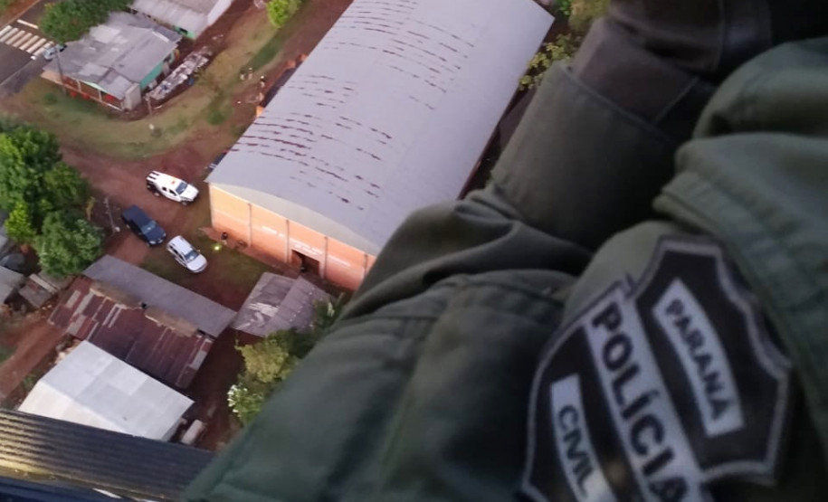 Policial civil sobrevoando o local, de helicóptero