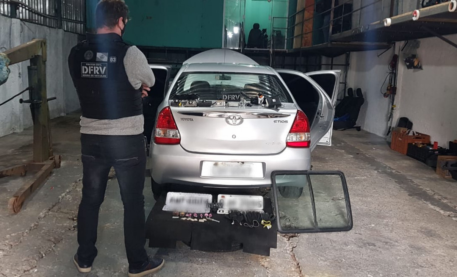 Policial civil observa veículo no interior de barracão